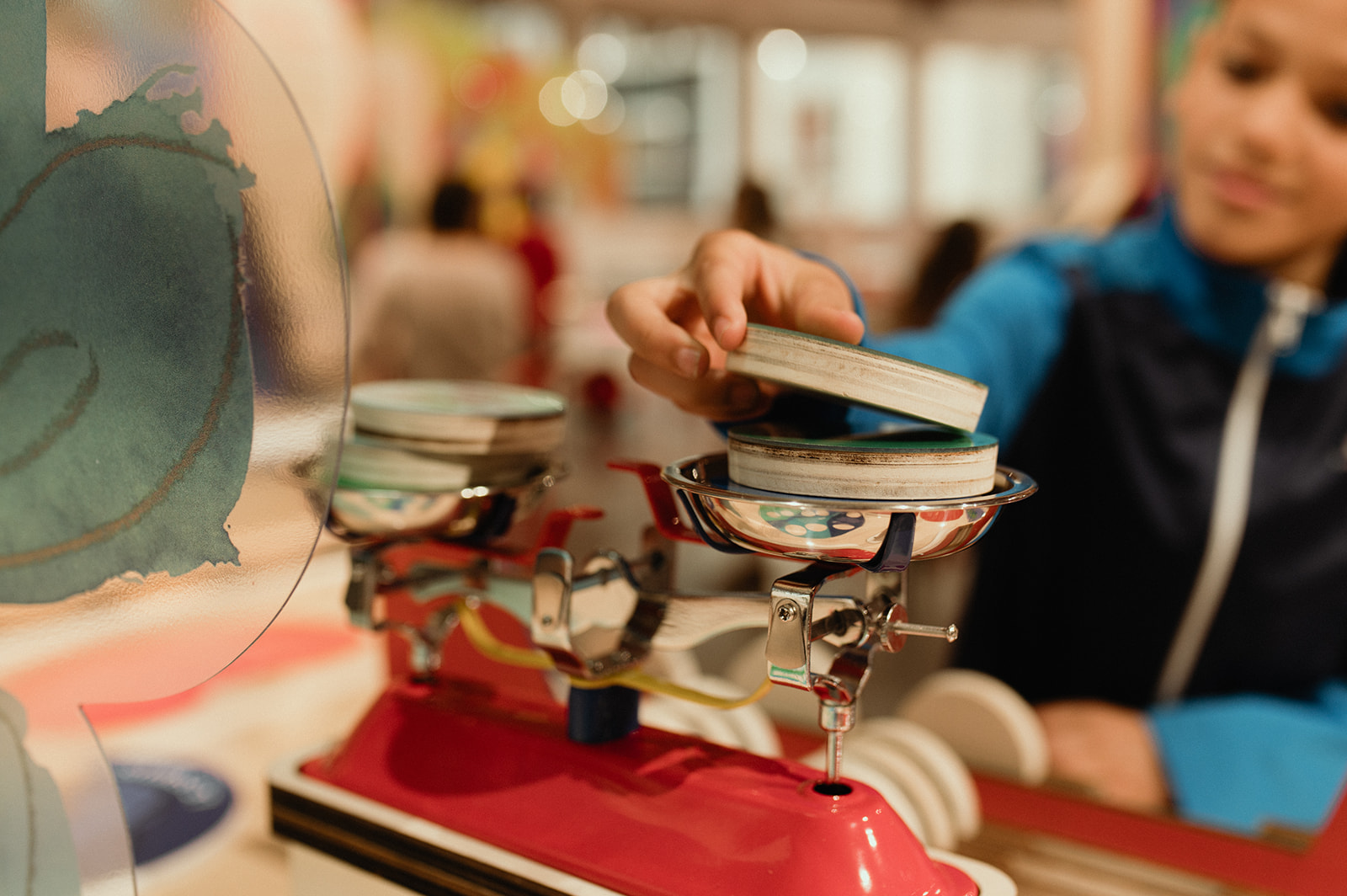 Photo d'un enfant posant un poid sur une balance lors d'une activité ludique de l'exposition graines